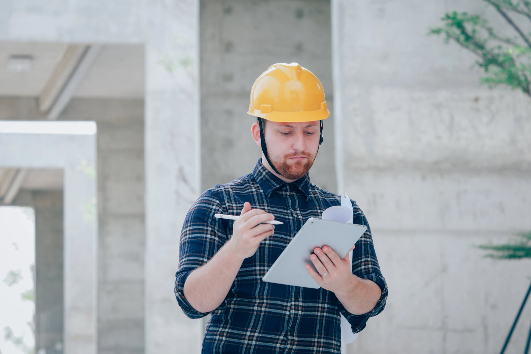 Construction worker with hard hat checking tablet